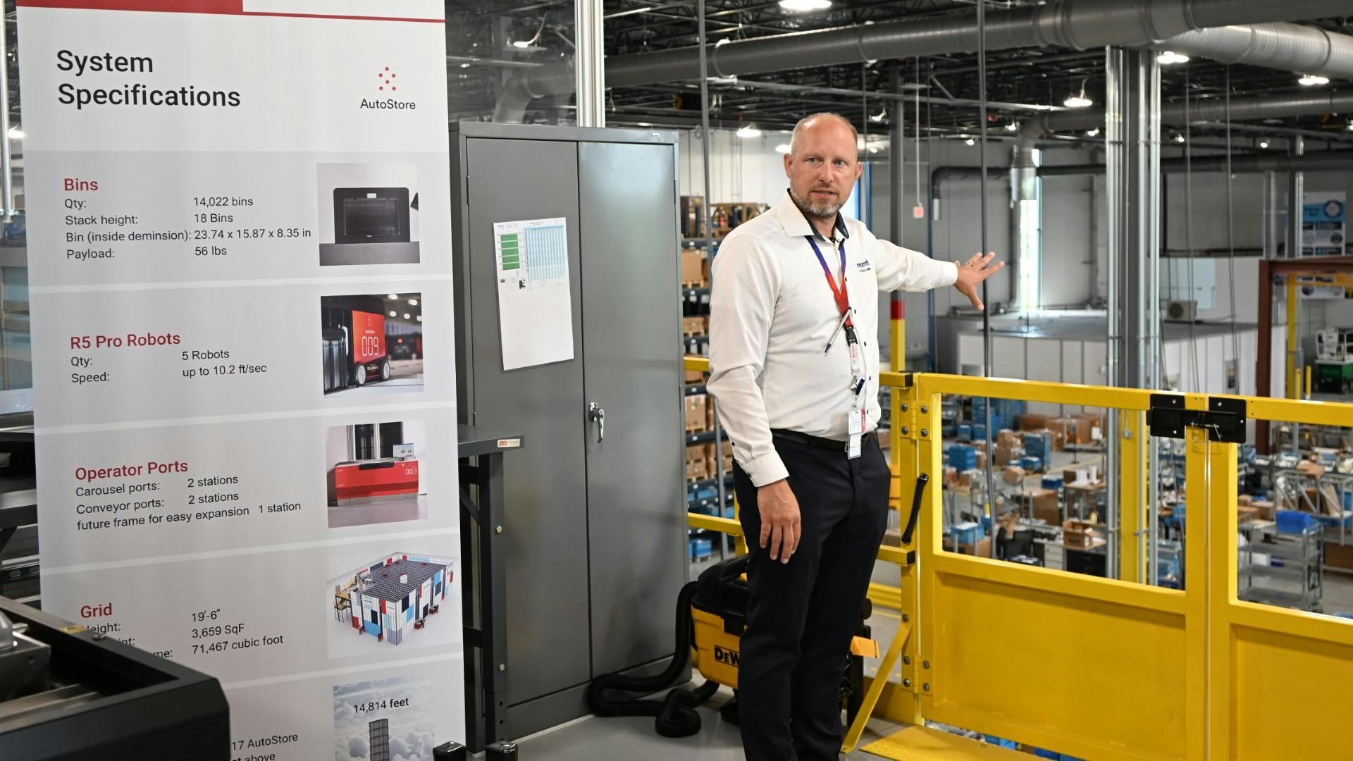 A Bosch Rexroth employee stands beside a systems specifications poster.