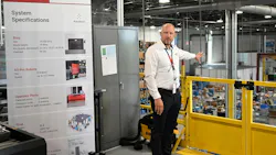 A Bosch Rexroth employee stands beside a systems specifications poster.