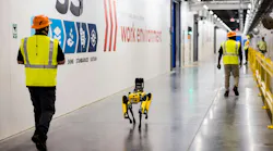 Purina employees and robot dog, Spot, walk the hall of Purina’s new pet food factory in Ohio during its grand opening on August 31, 2026. Spot, created by Boston Dynamics, is trained to conduct thermal and acoustic inspections of machinery as part of the factory’s digital manufacturing program. Image and caption credit: Purina