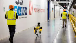Purina employees and robot dog, Spot, walk the hall of Purina’s new pet food factory in Ohio during its grand opening on August 31, 2026. Spot, created by Boston Dynamics, is trained to conduct thermal and acoustic inspections of machinery as part of the factory’s digital manufacturing program. Image and caption credit: Purina
