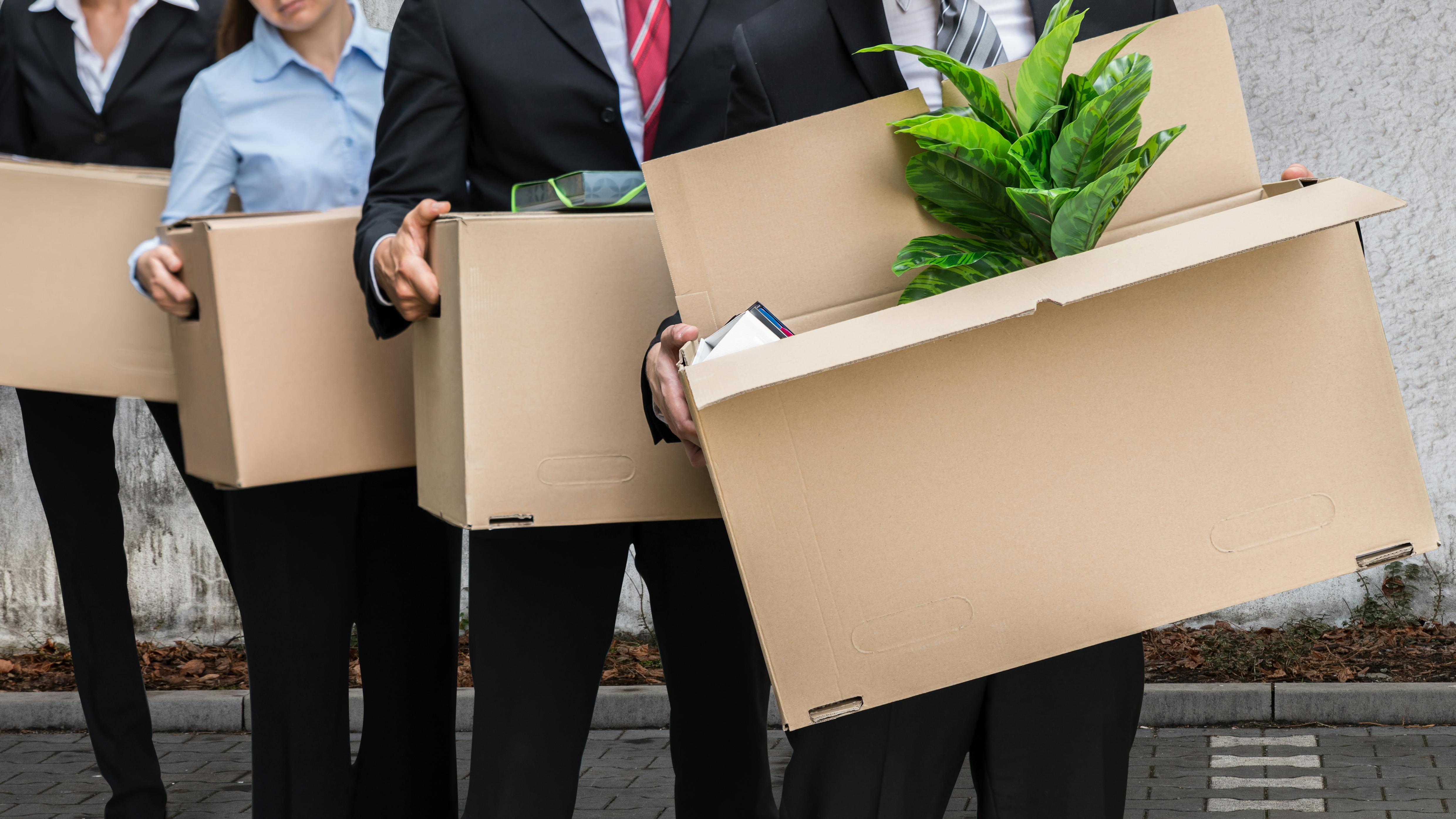 Workers with items in boxes, having been dismissed
