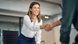 A businesswoman shakes hands with a businessman