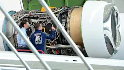 Two technicians examine a jet engine