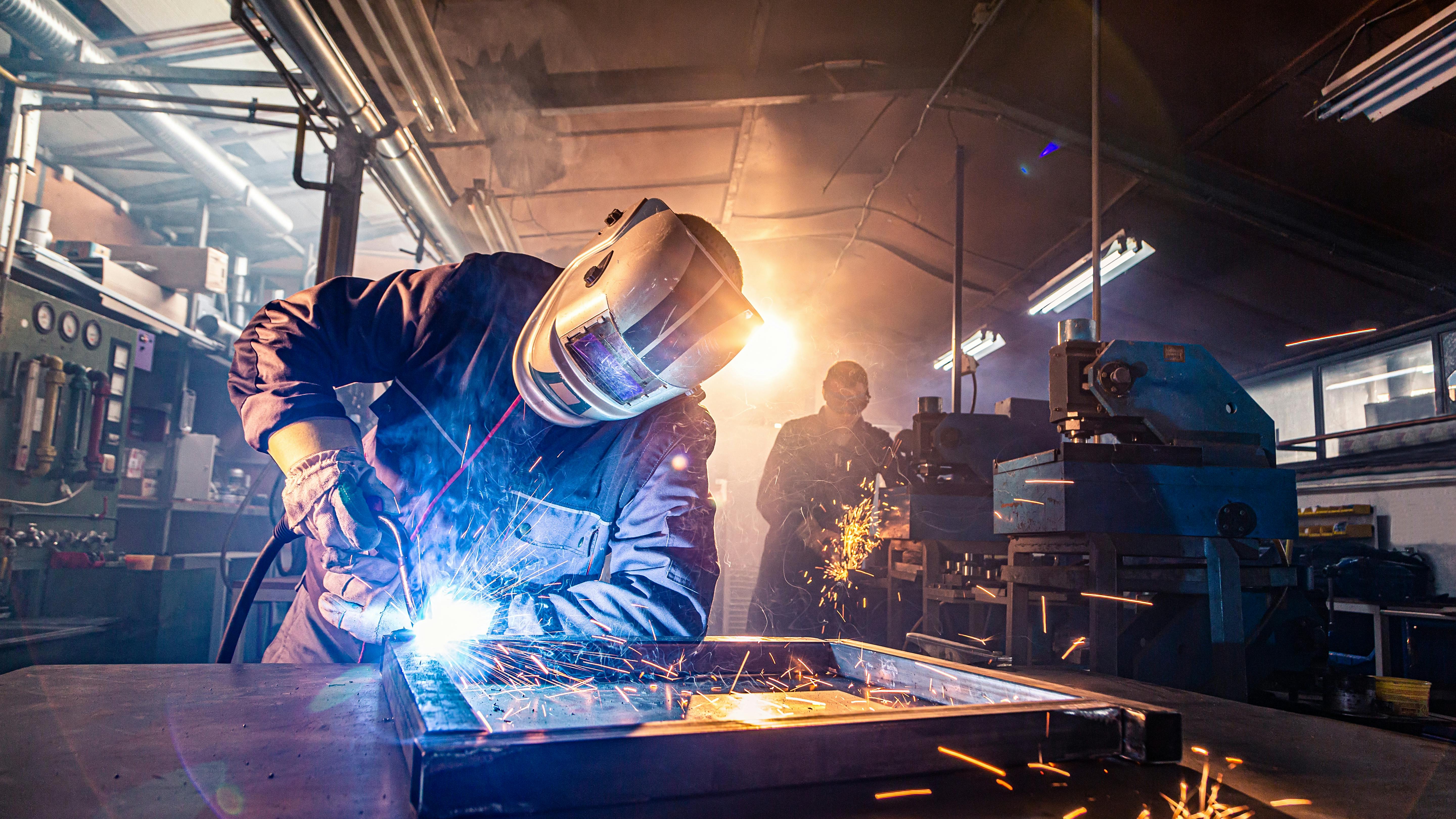 Workers welding and grinding