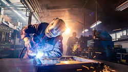 Workers welding and grinding