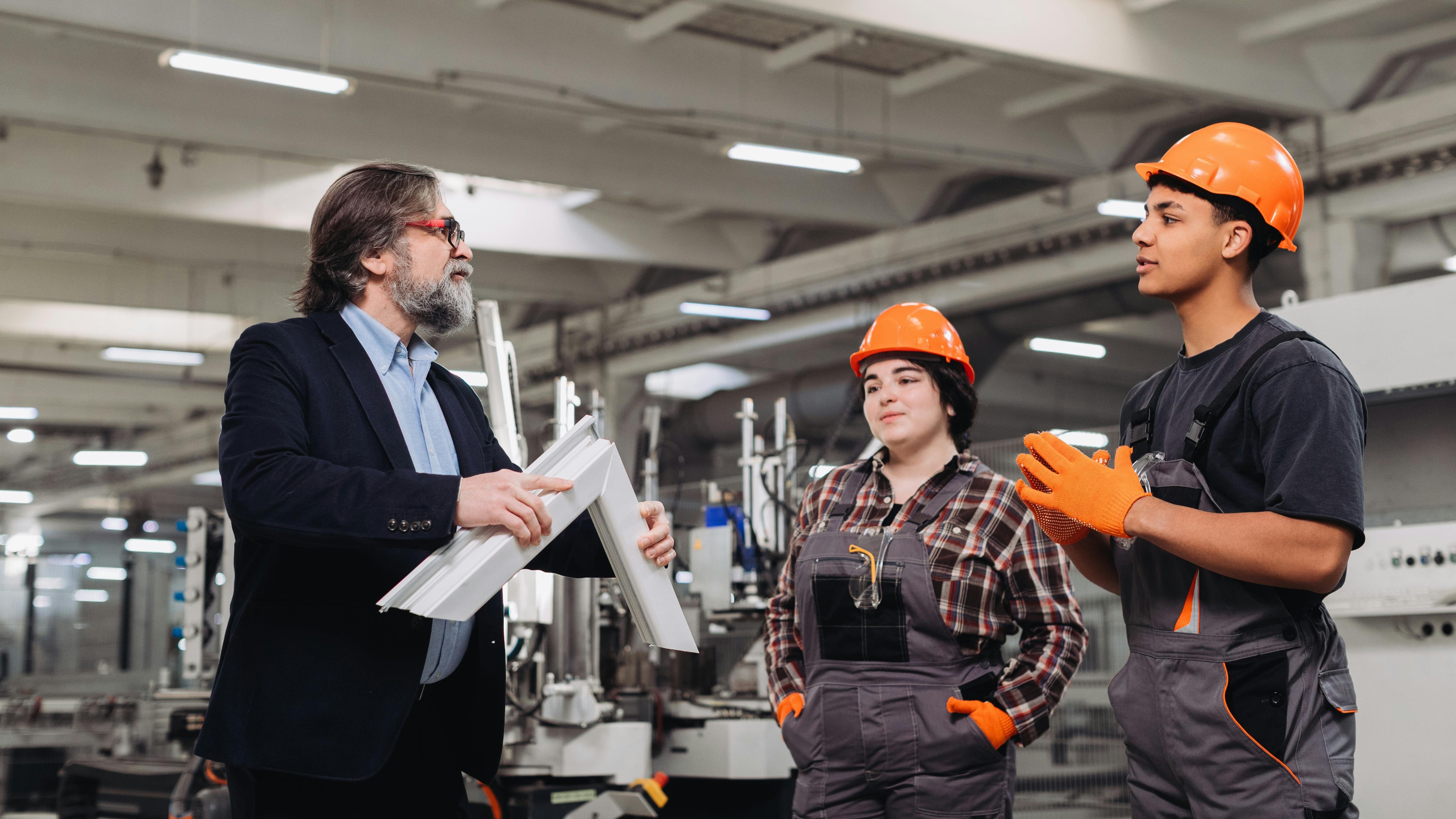 An experienced worker trains two apprentices