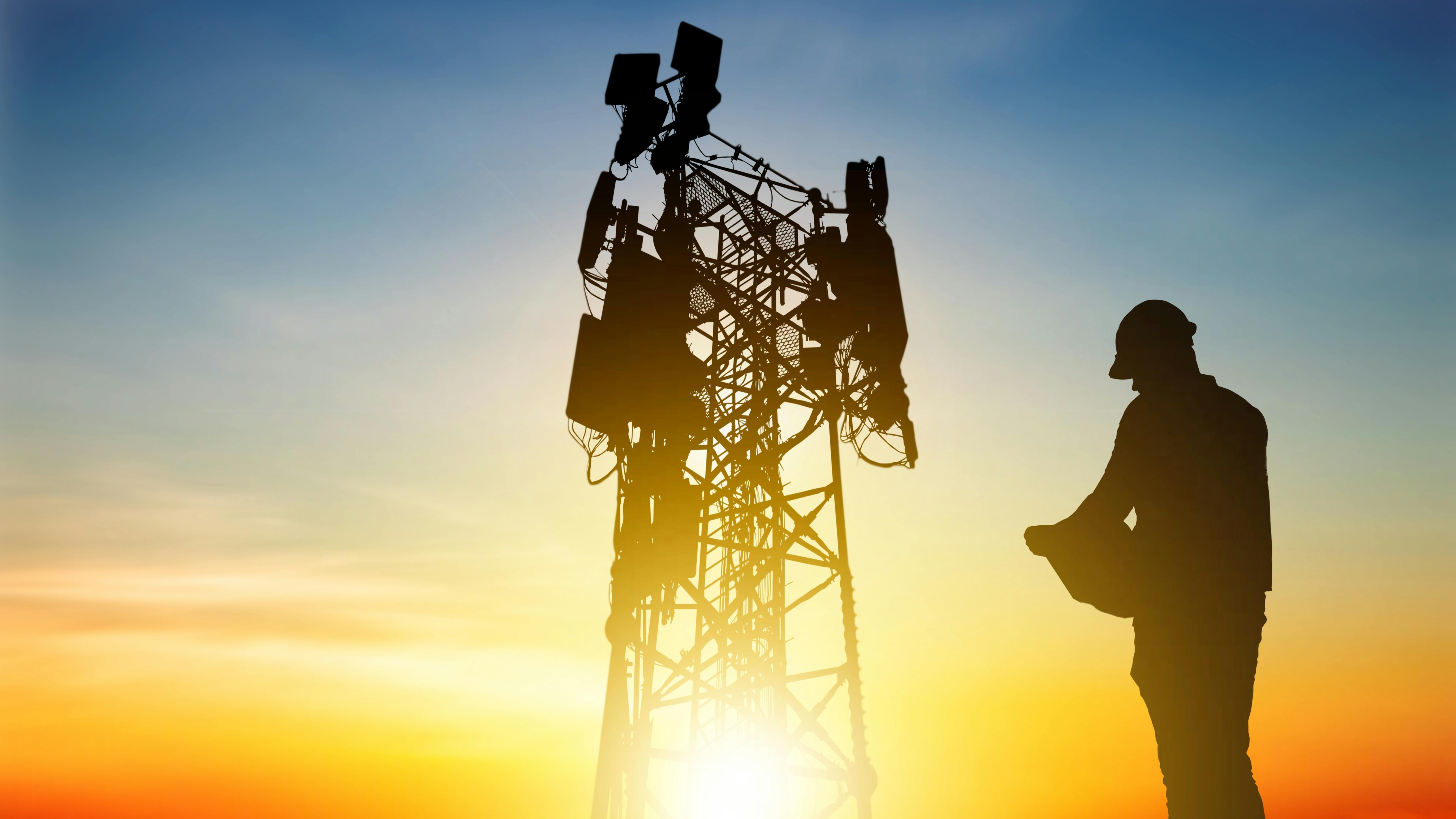 A worker approaches a 5G tower